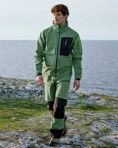 Dark Moss coloured Didriksons Mens Fractus Pants on sea background 