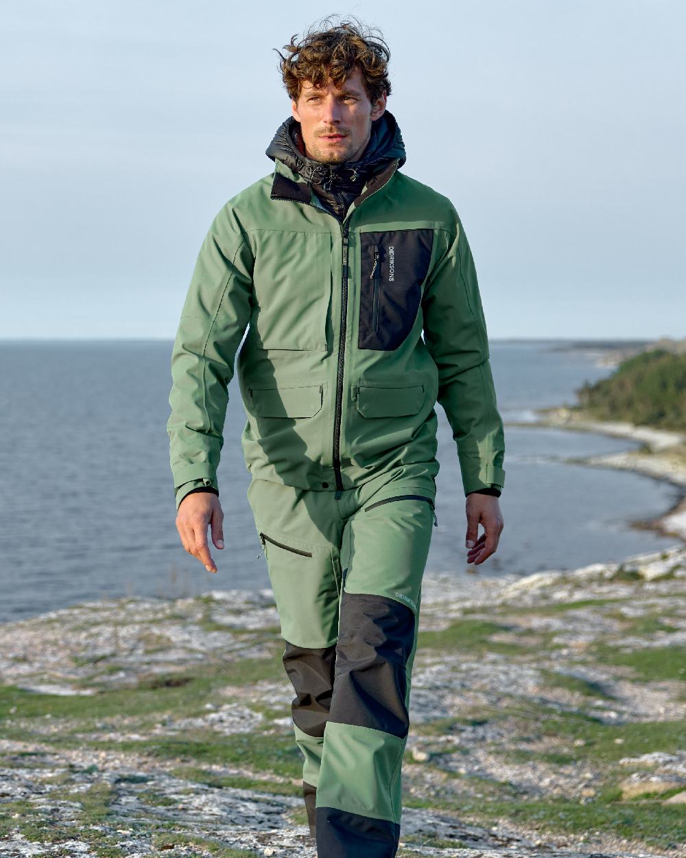 Dark Moss coloured Didriksons Mens Fractus Pants on sea background 