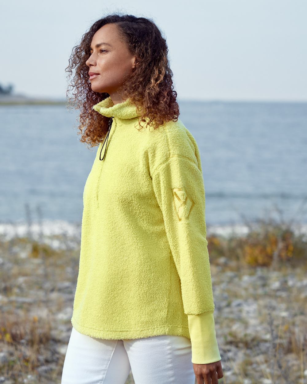 Light Avocado coloured Didriksons Womens Monia Half Zip Sweater on coastal background 