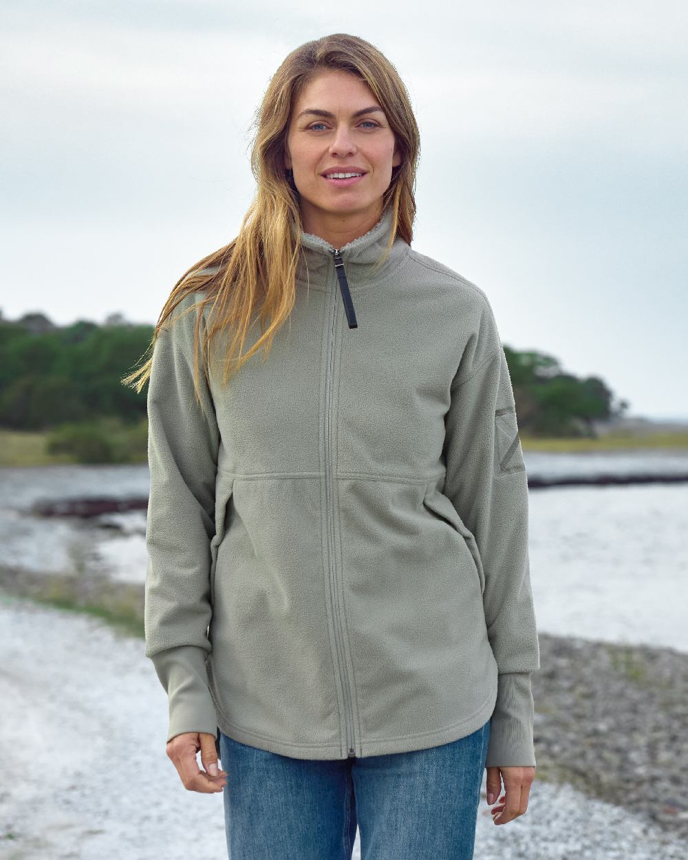 Wilted Leaf coloured Didriksons Womens Ronja Full Zip Sweater on coastal background 