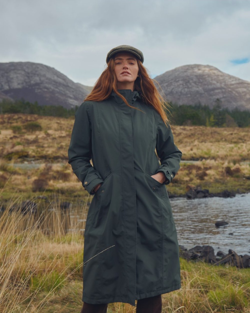 Pesto Coloured Dubarry Alderford Waterproof Coat On A Mountain Background 