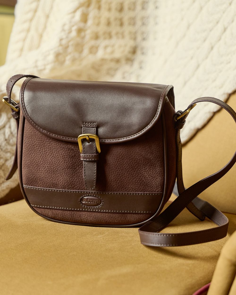 Mocha coloured Dubarry Clara Leather Saddle Bag on indoor background 