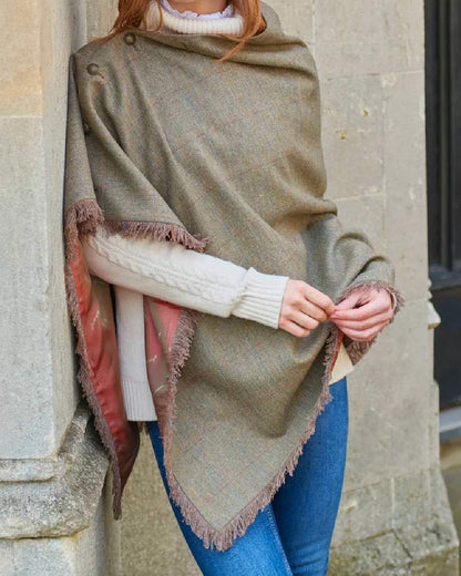 Burren Coloured Dubarry Hazelwood Tweed Poncho on wall background 