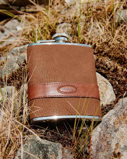 Walnut coloured Dubarry Rugby Hip Flask on rock background 