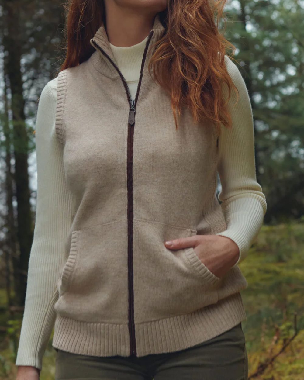 Oat Coloured Dubarry Sheedy Knit Bodywarmer on forest background 