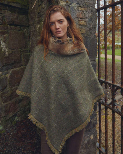 Thistle Coloured Dubarry Womens Silverfir Tweed Poncho on wall background 