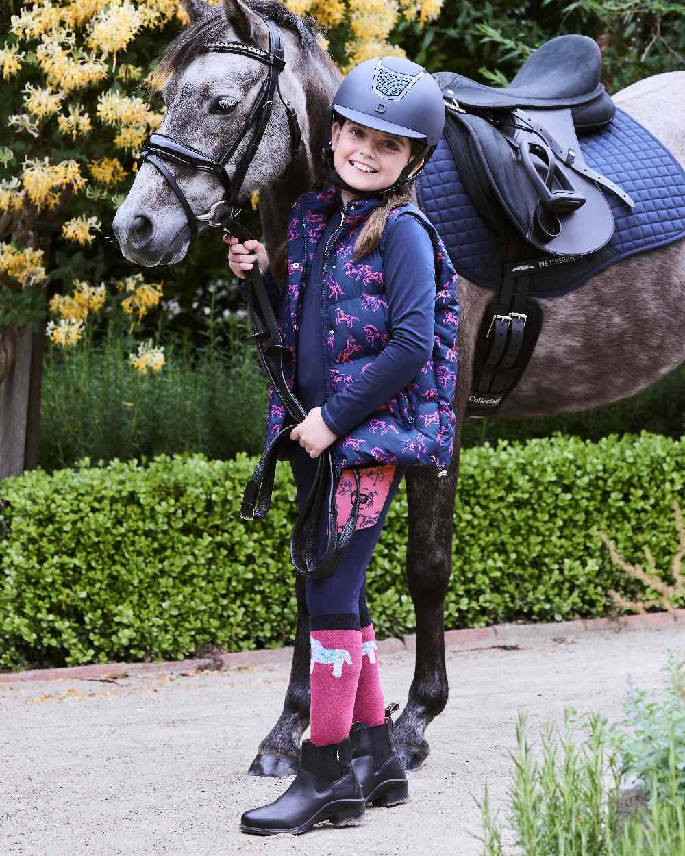 Navy Frolicking Horses coloured Dublin Childrens Patrice Everyday Puffer Vest on street background 