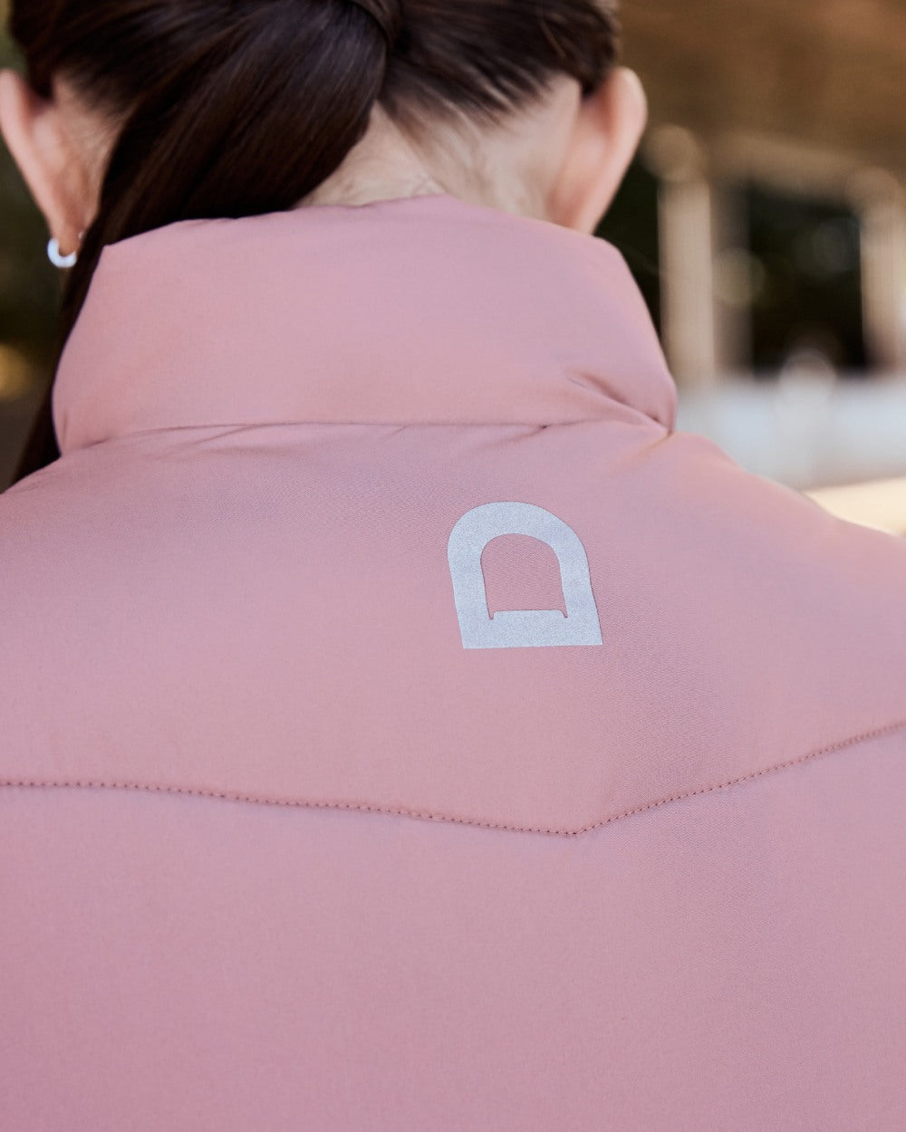Dusty Rose coloured Dublin Kids Puffer Body Warmer on blurry background 