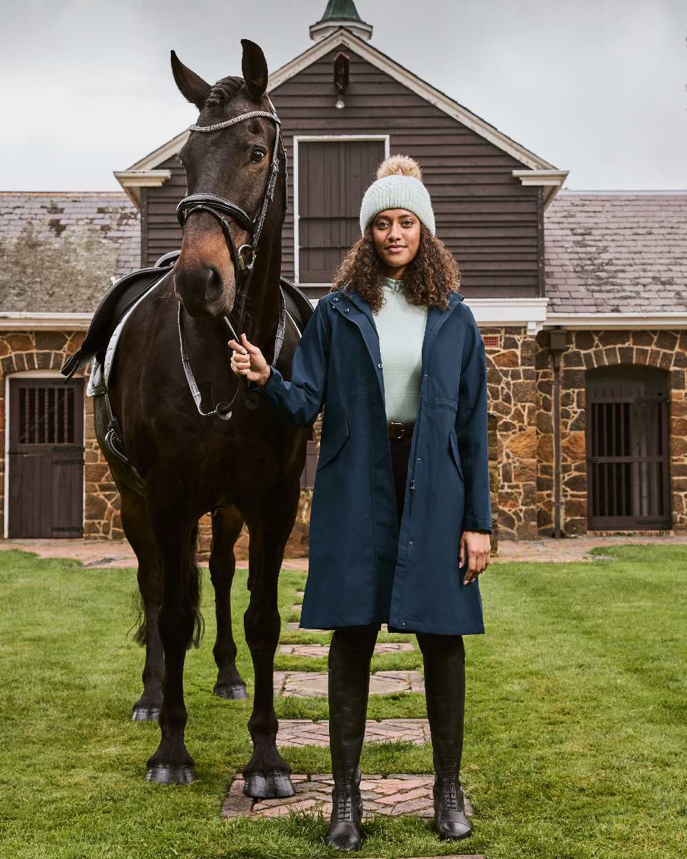 Sky Captain coloured Dublin Rowan Waterproof Riding Coat on house background 