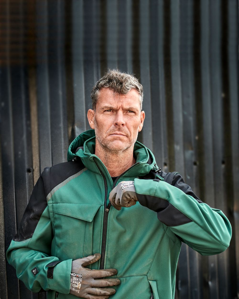 Green Black Coloured Elka Mens Working Xtreme Softshell Jacket With Detachable Sleeves on blurry background 