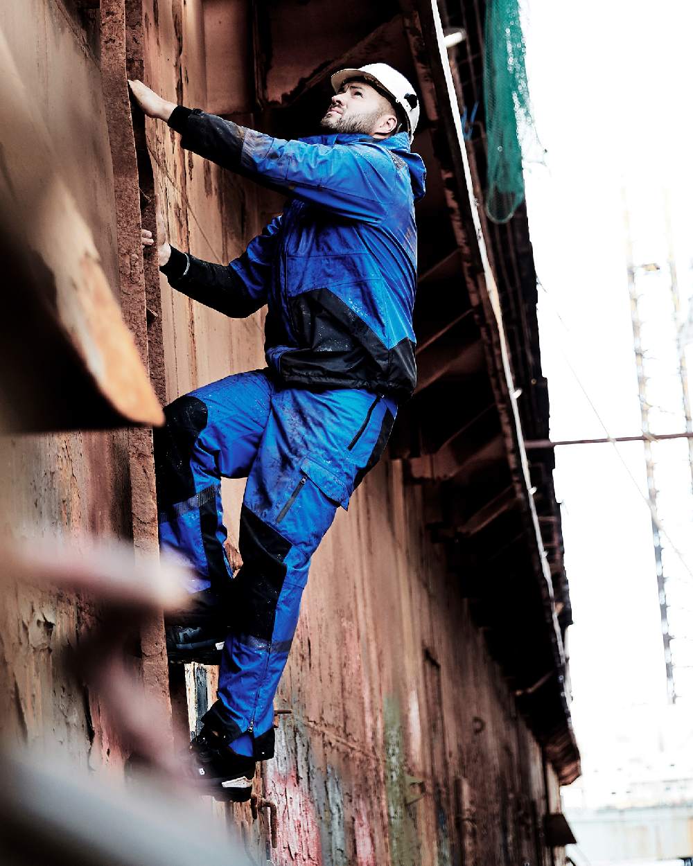 Royal Blue Black Coloured Elka Mens Working Xtreme Stretch Waist Trousers on construction background 