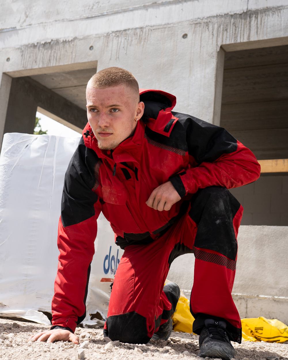Red Black Coloured Elka Mens Working Xtreme Stretch Winter Jacket on building background 