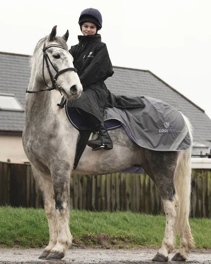 Black coloured Equidry Children Pro Ride Evolution Thin Fleece With Stowaway Hood on farm background 