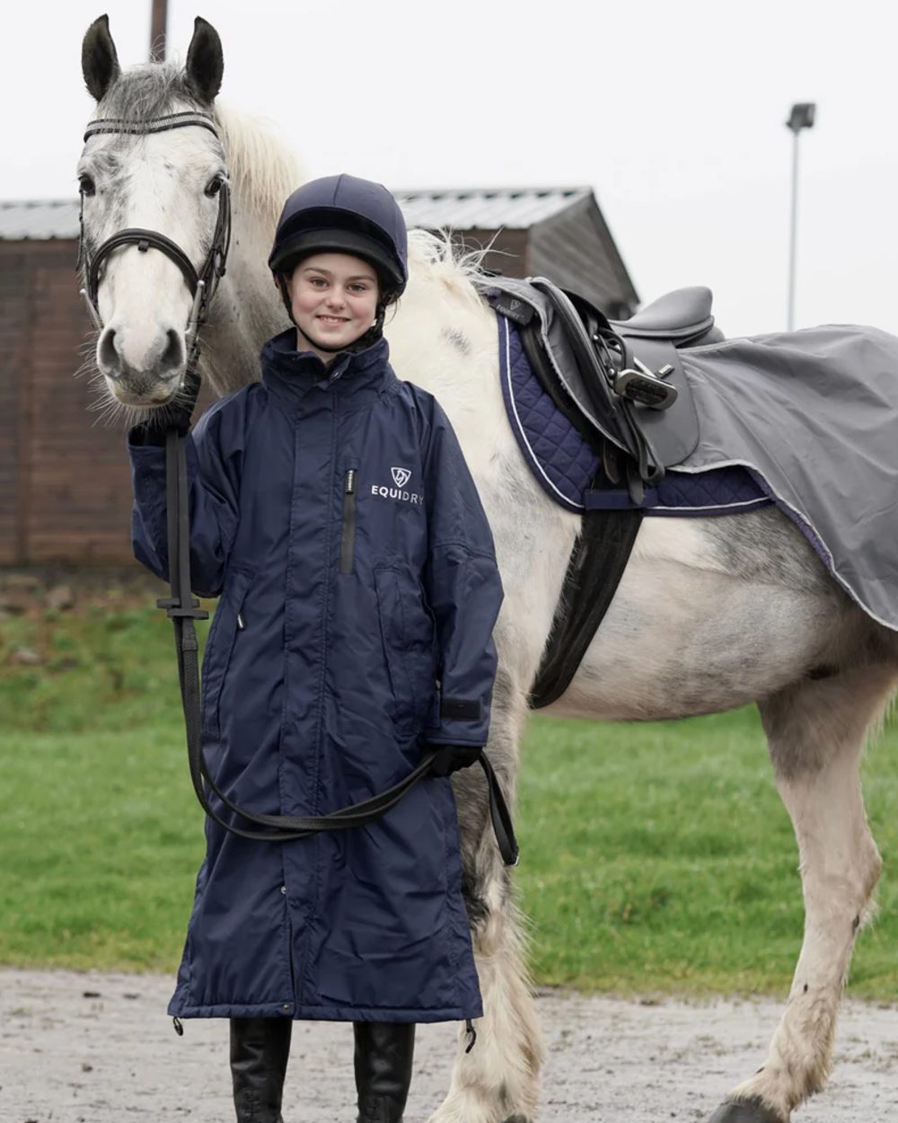 Navy coloured Equidry Children Pro Ride Evolution Thin Fleece With Stowaway Hood on outdoor background 