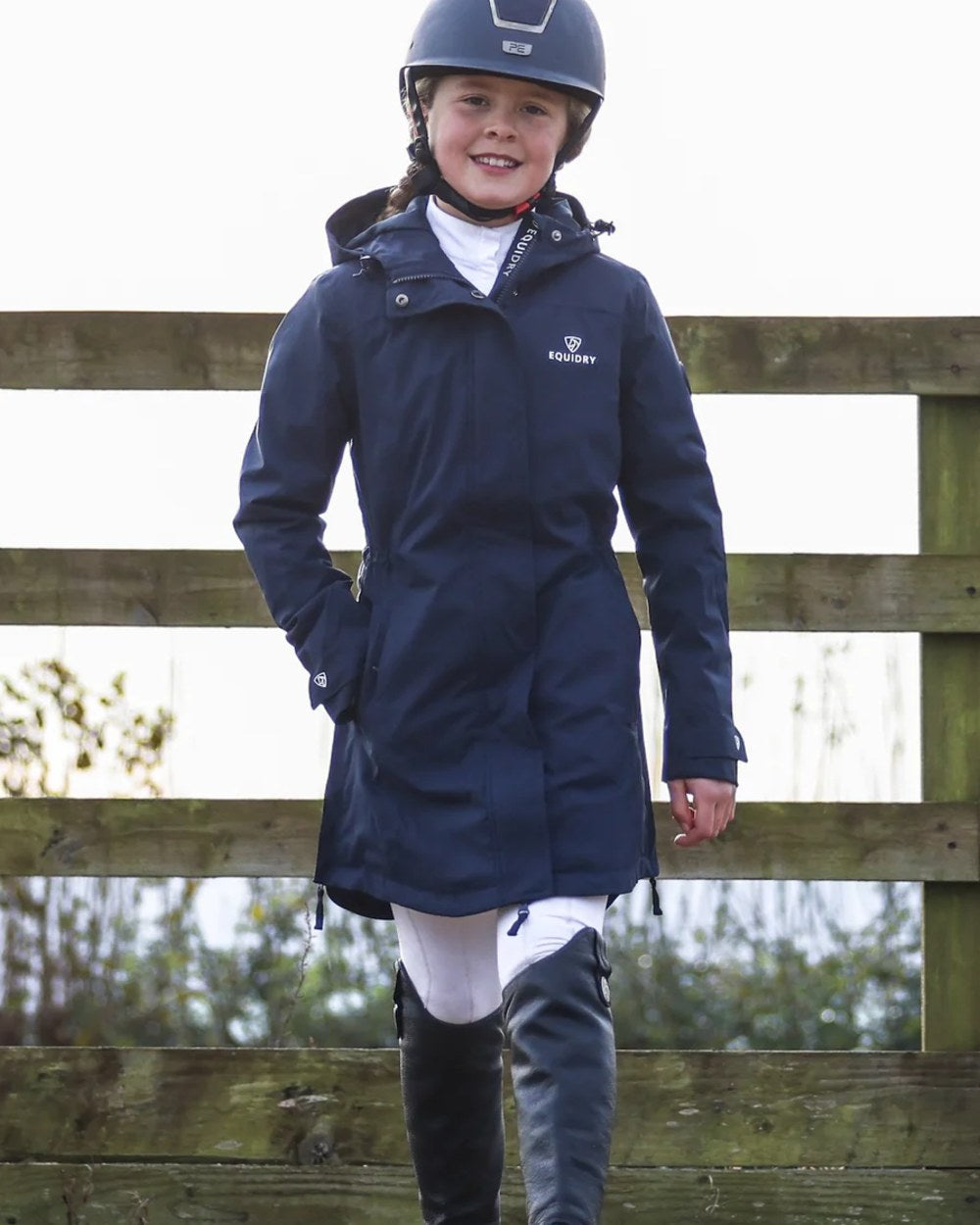 Navy coloured Equidry Childrens Bronte Riding Coat on outdoor background 