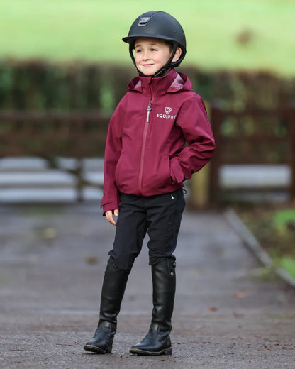 Plum coloured Equidry Childrens Nimbus Pack Away Jacket With Stowaway Hood on outdoor background 