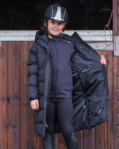 Black coloured Equidry Childrens Thora Waterproof Riding Puffer Jacket With Hood on stable background 