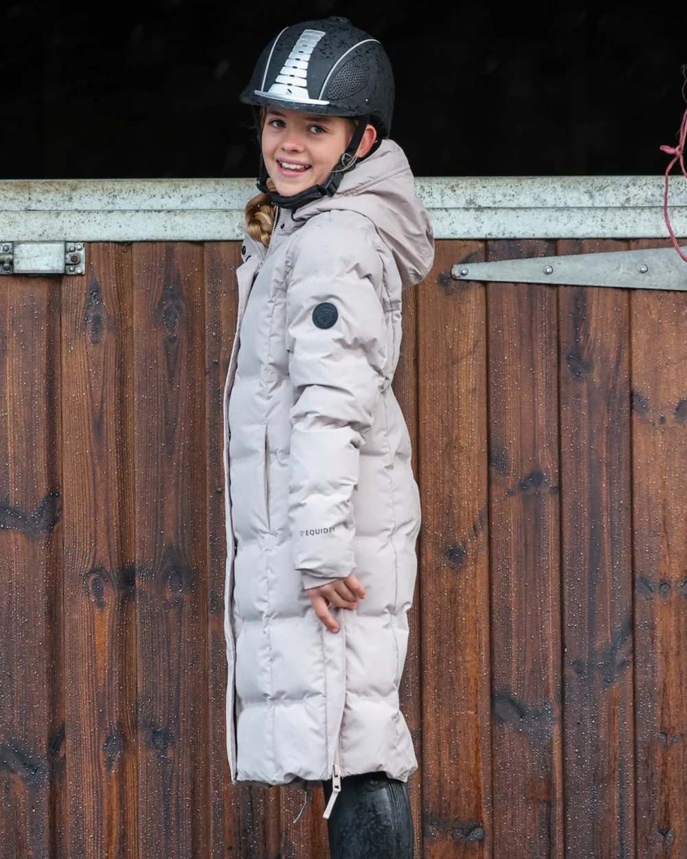 Taupe coloured Equidry Childrens Thora Waterproof Riding Puffer Jacket With Hood on stable background 