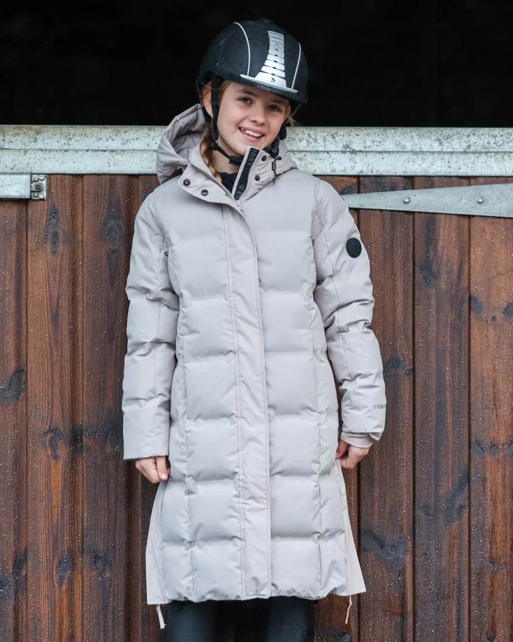 Taupe coloured Equidry Childrens Thora Waterproof Riding Puffer Jacket With Hood on stable background 