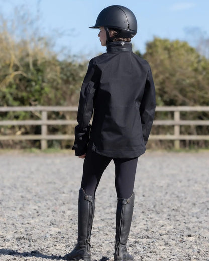 Black coloured Equidry Childrens Varsha Waterproof Jacket on farm background 