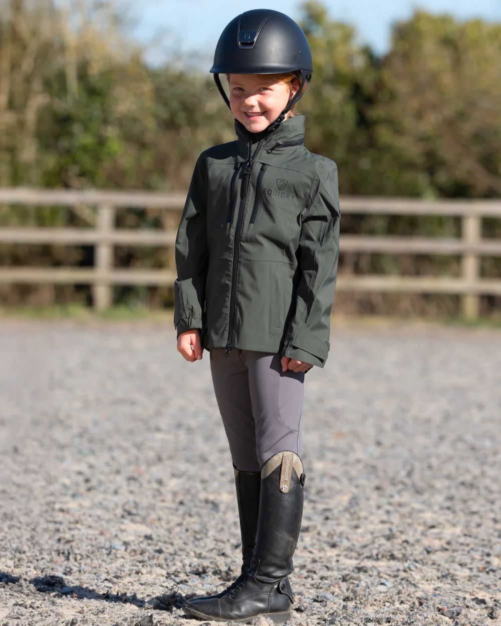 Khaki Equidry Childrens Varsha Waterproof Jacket on yard background 