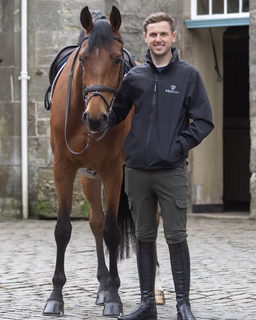 Black coloured Equidry Mens Nimbus Pack Away Jacket With Stowaway Hood on outdoor background 