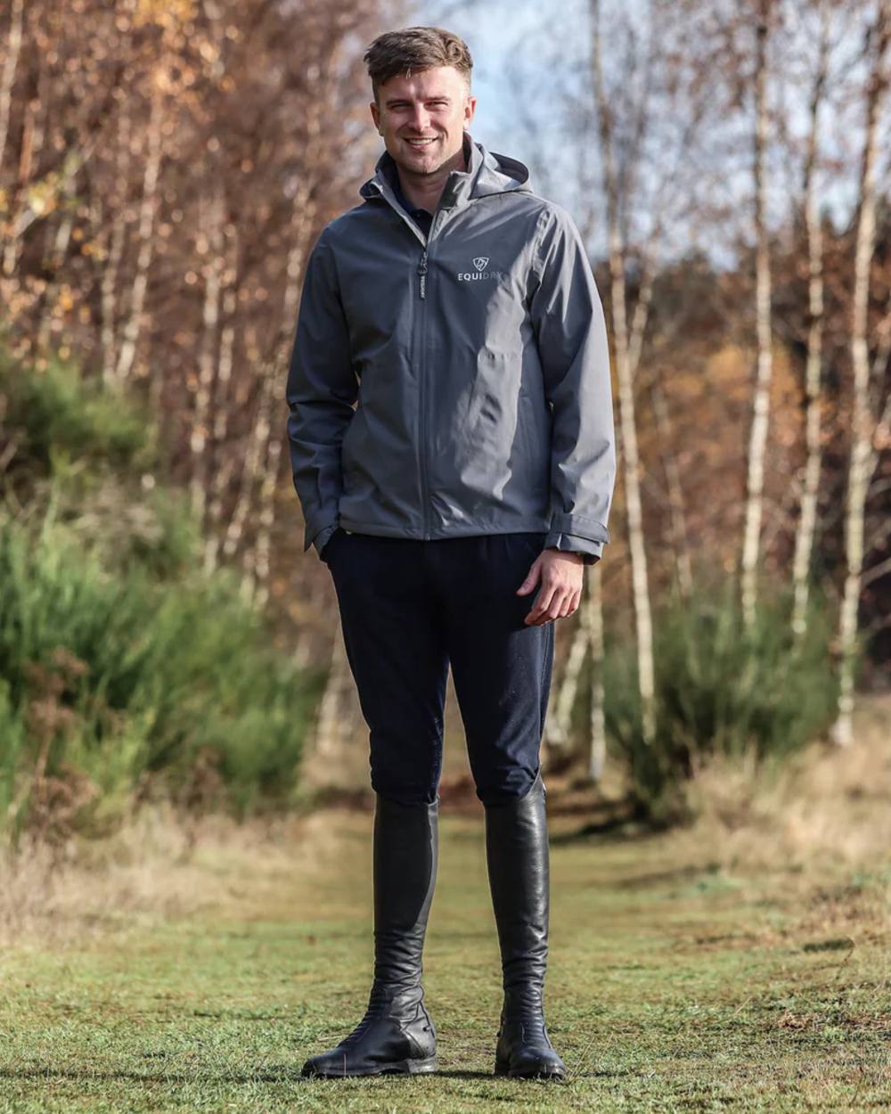Charcoal coloured Equidry Mens Nimbus Pack Away Jacket With Stowaway Hood on forest background 