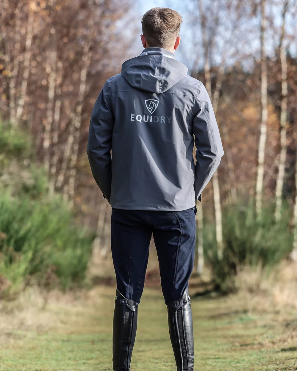 Charcoal coloured Equidry Mens Nimbus Pack Away Jacket With Stowaway Hood on forest background 