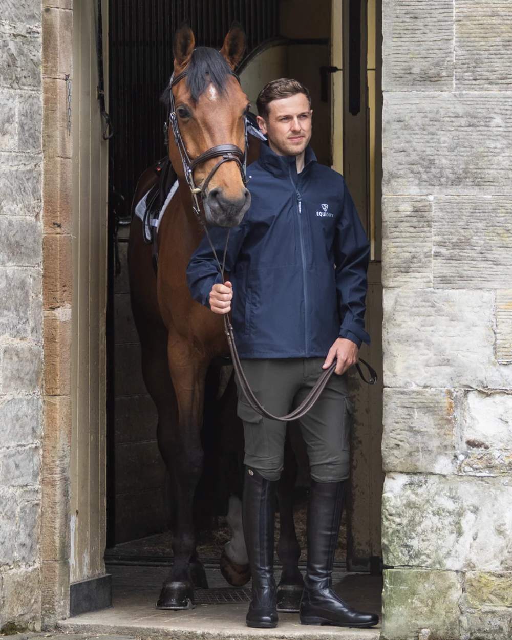 Navy coloured Equidry Mens Nimbus Pack Away Jacket With Stowaway Hood on outdoor background 