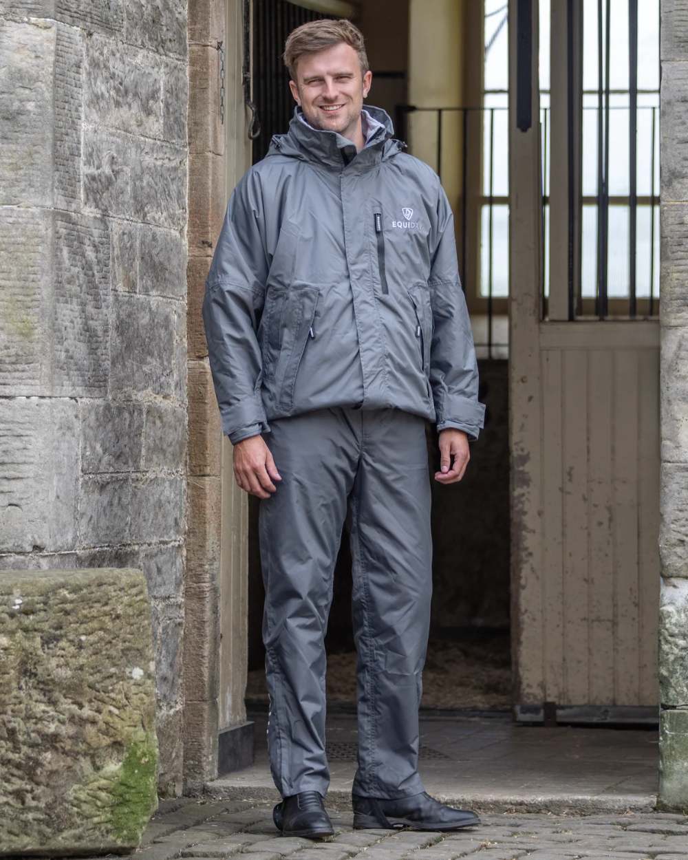Charcoal coloured Equidry Mens Unlined Waterproof Trousers on outdoor background 