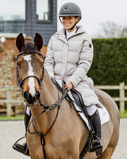 Taupe coloured Equidry Thora Waterproof Riding Puffer Coat With Hood on outdoor background 