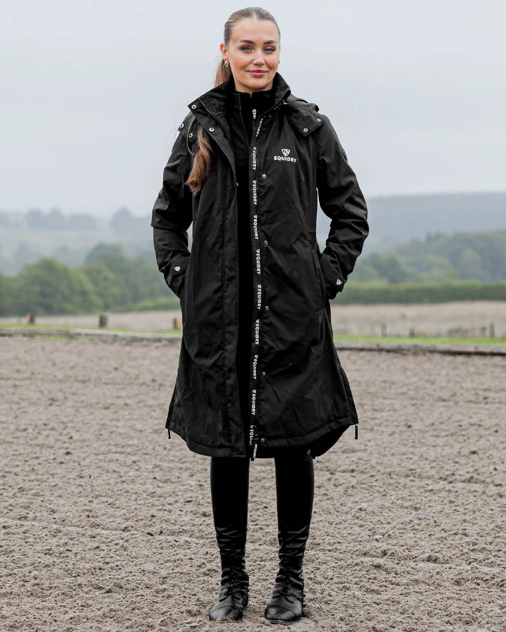 Black Coloured Equidry Womens Bronte Riding Coat With Removable Hood on outdoor background 