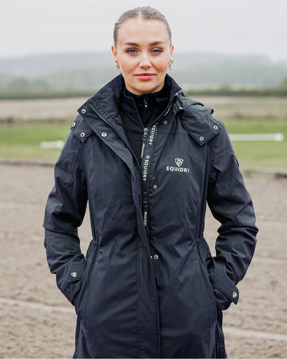 Navy Coloured Equidry Womens Bronte Riding Coat With Removable Hood on outdoor background 