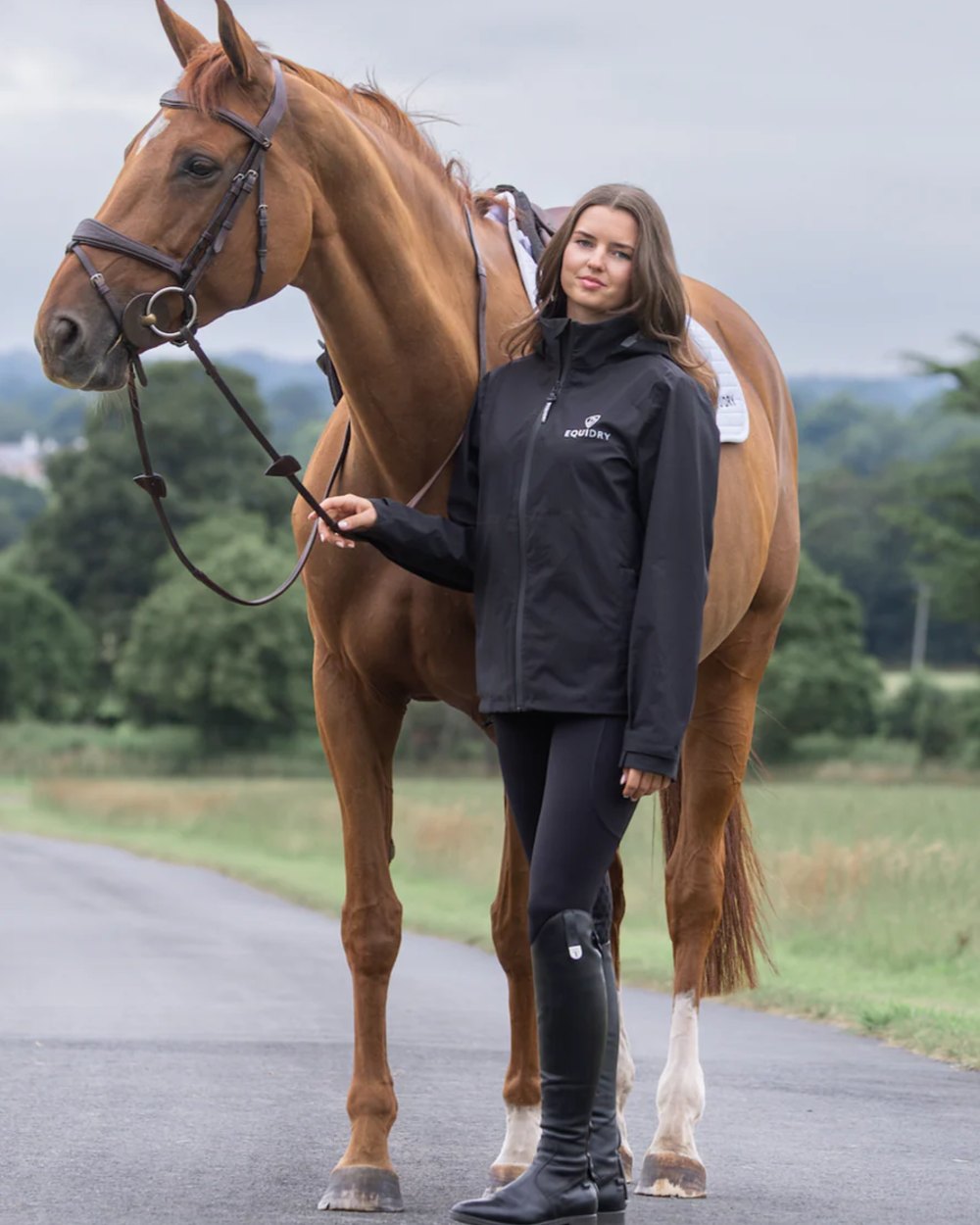 Black coloured Equidry Womens Nimbus Pack Away Jacket with Stowaway Hood on street background 