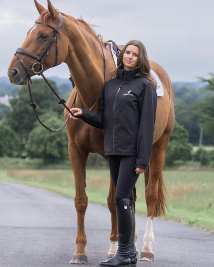 Black coloured Equidry Womens Nimbus Pack Away Jacket with Stowaway Hood on street background 