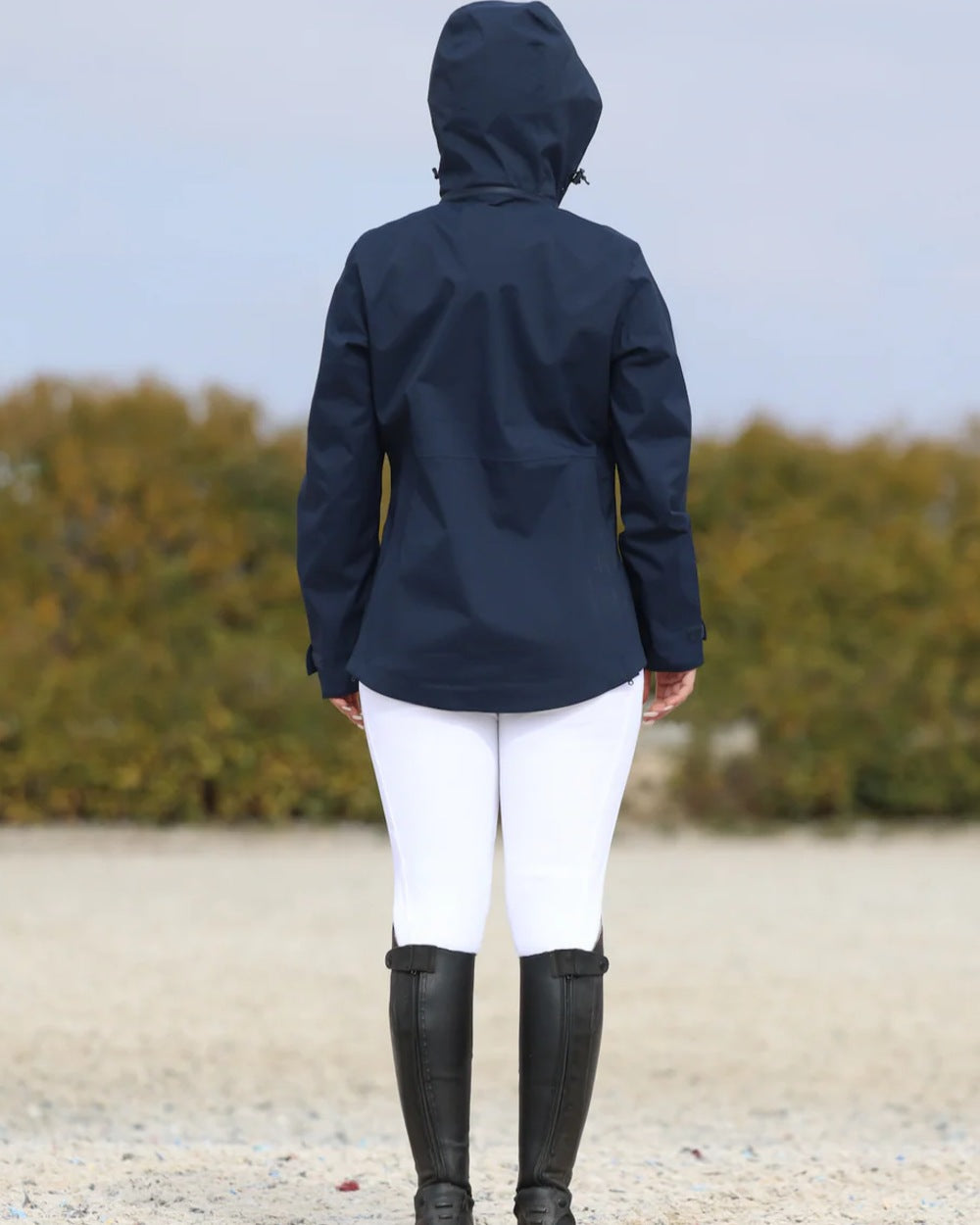 Navy coloured Equidry Womens Varsha Jacket with Stowaway Hood on sand background 