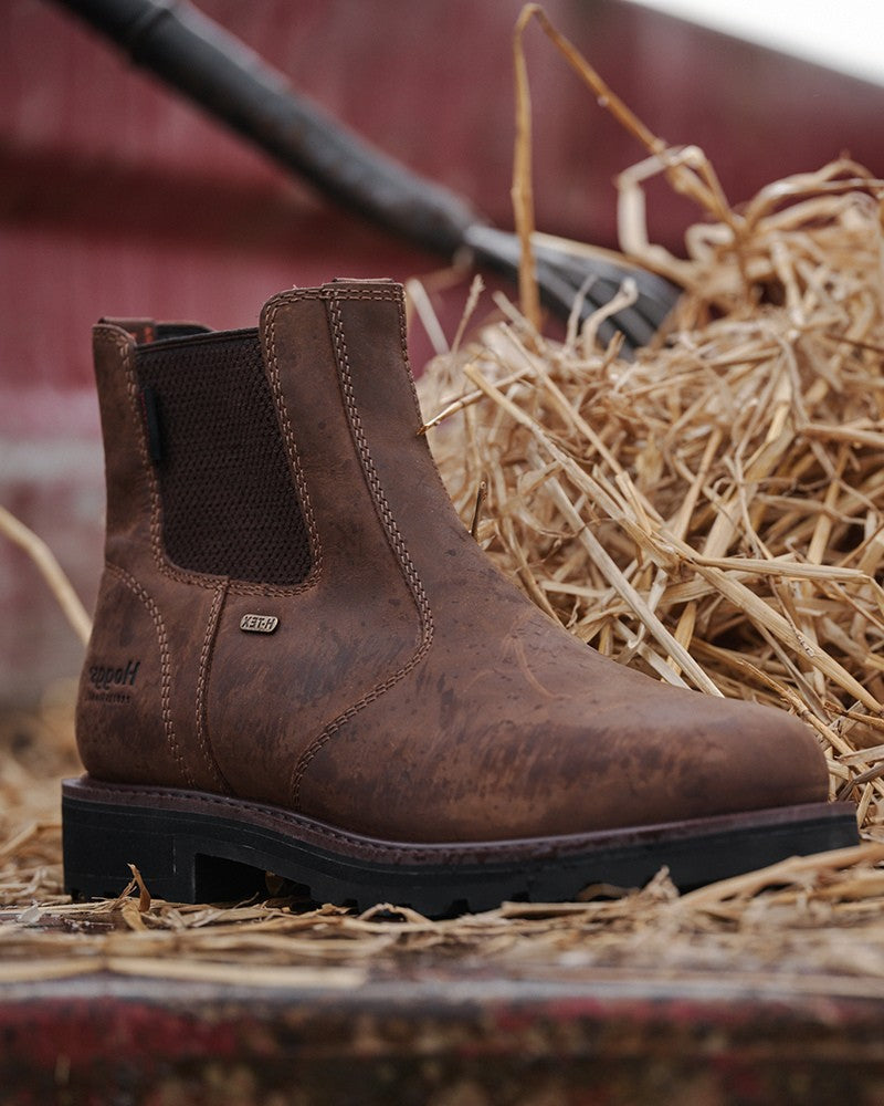 Pair of Hoggs of Fife brown leather Chelsea boots displayed beside straw bales