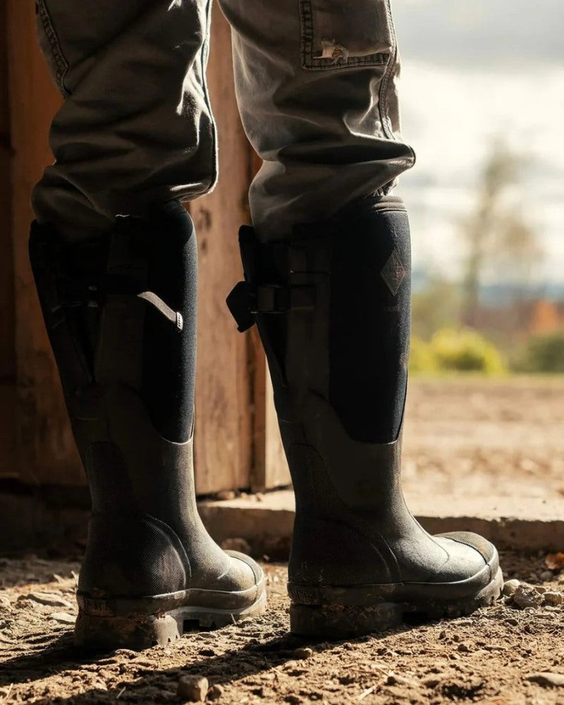 Person wearing Muck Boots waterproof wellington boots inside a barn doorway