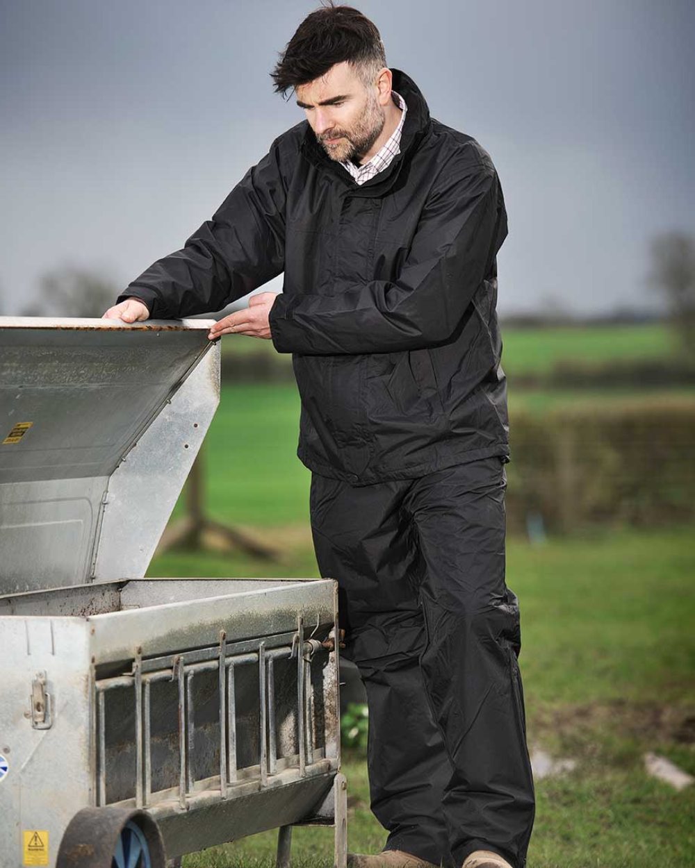 Black coloured Fort Rutland Waterproof Over Trousers on farm background 