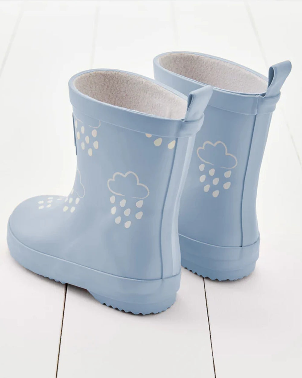 Baby Blue coloured Grass &amp; Air Childrens Colour-Revealing Wellies on wooden table background 