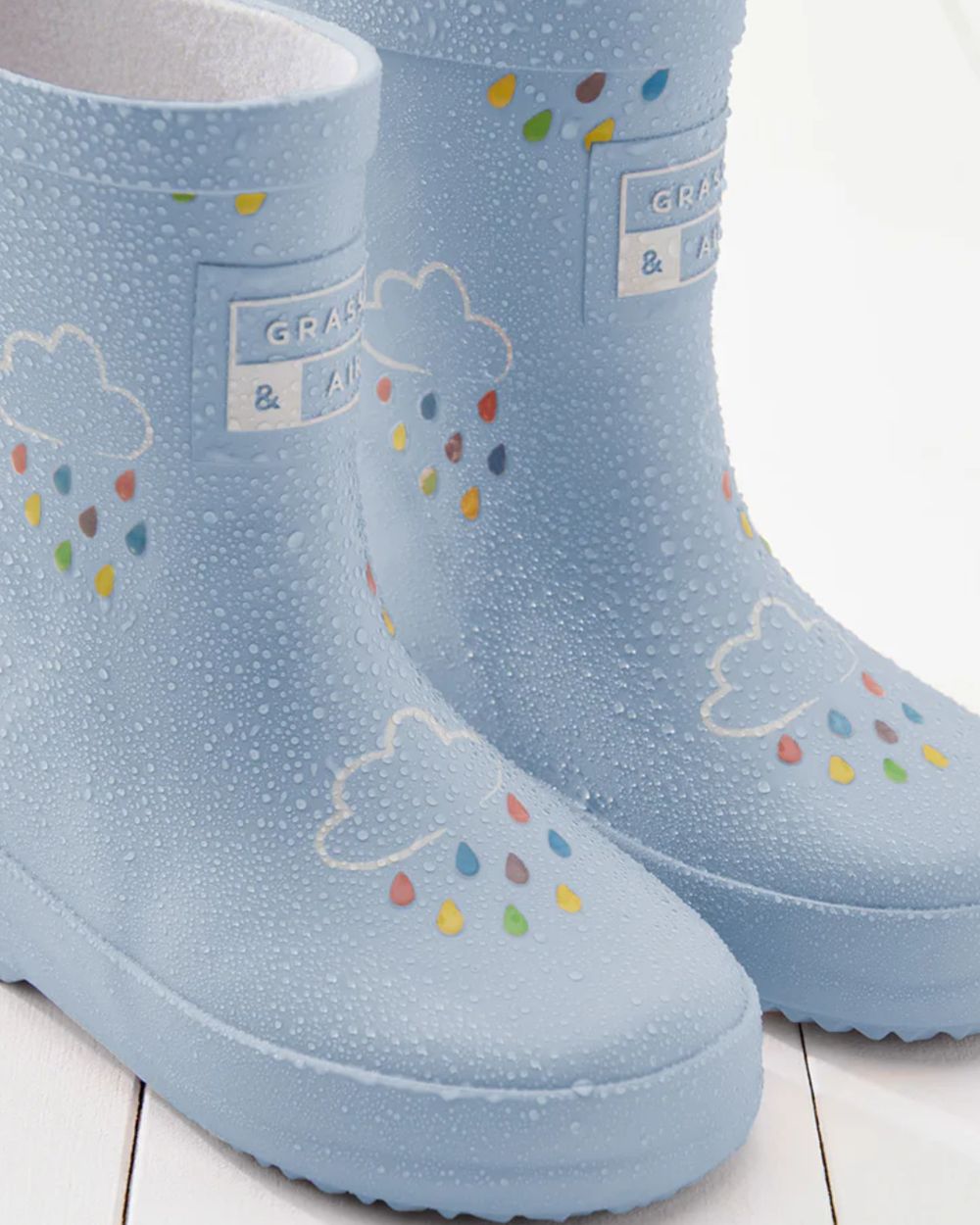 Baby Blue coloured Grass &amp; Air Childrens Colour-Revealing Wellies on wooden table background 