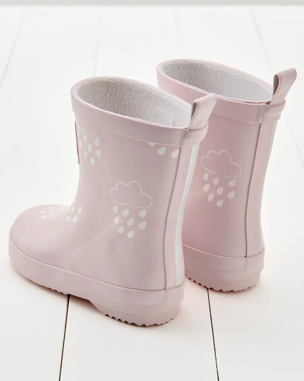 Baby Pink coloured Grass &amp; Air Childrens Colour-Revealing Wellies on wooden table background 