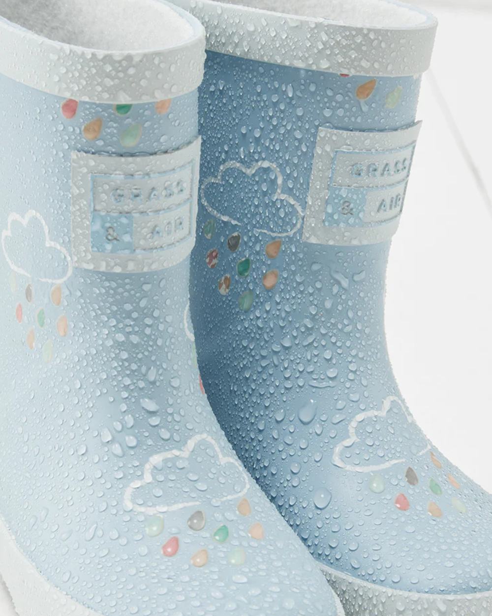 Ice Blue coloured Grass &amp; Air Childrens Colour-Revealing Wellies on wooden table background 
