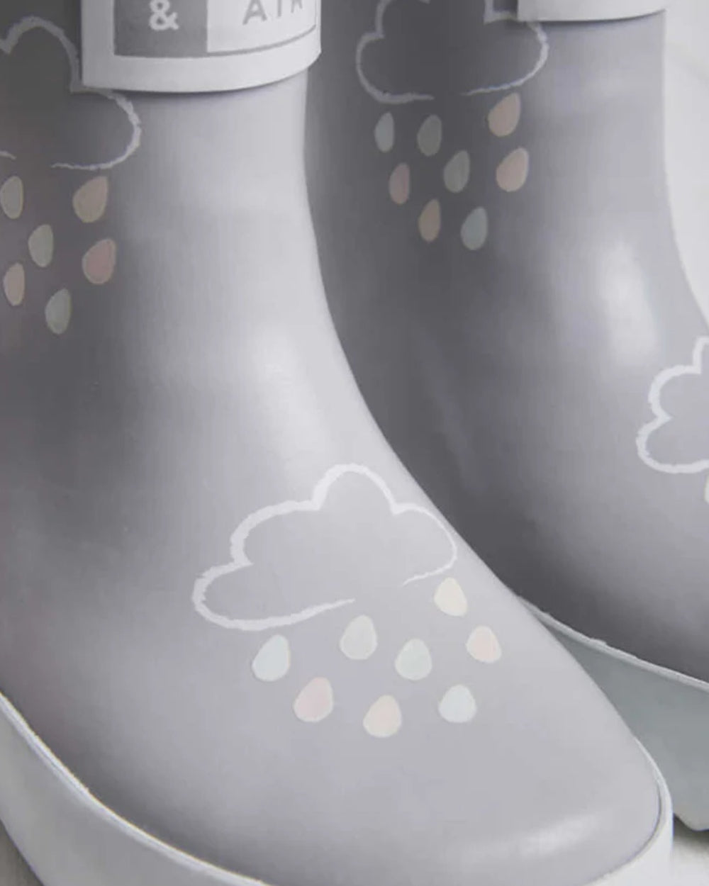 Light Grey coloured Grass &amp; Air Childrens Colour-Revealing Wellies on wooden table background 