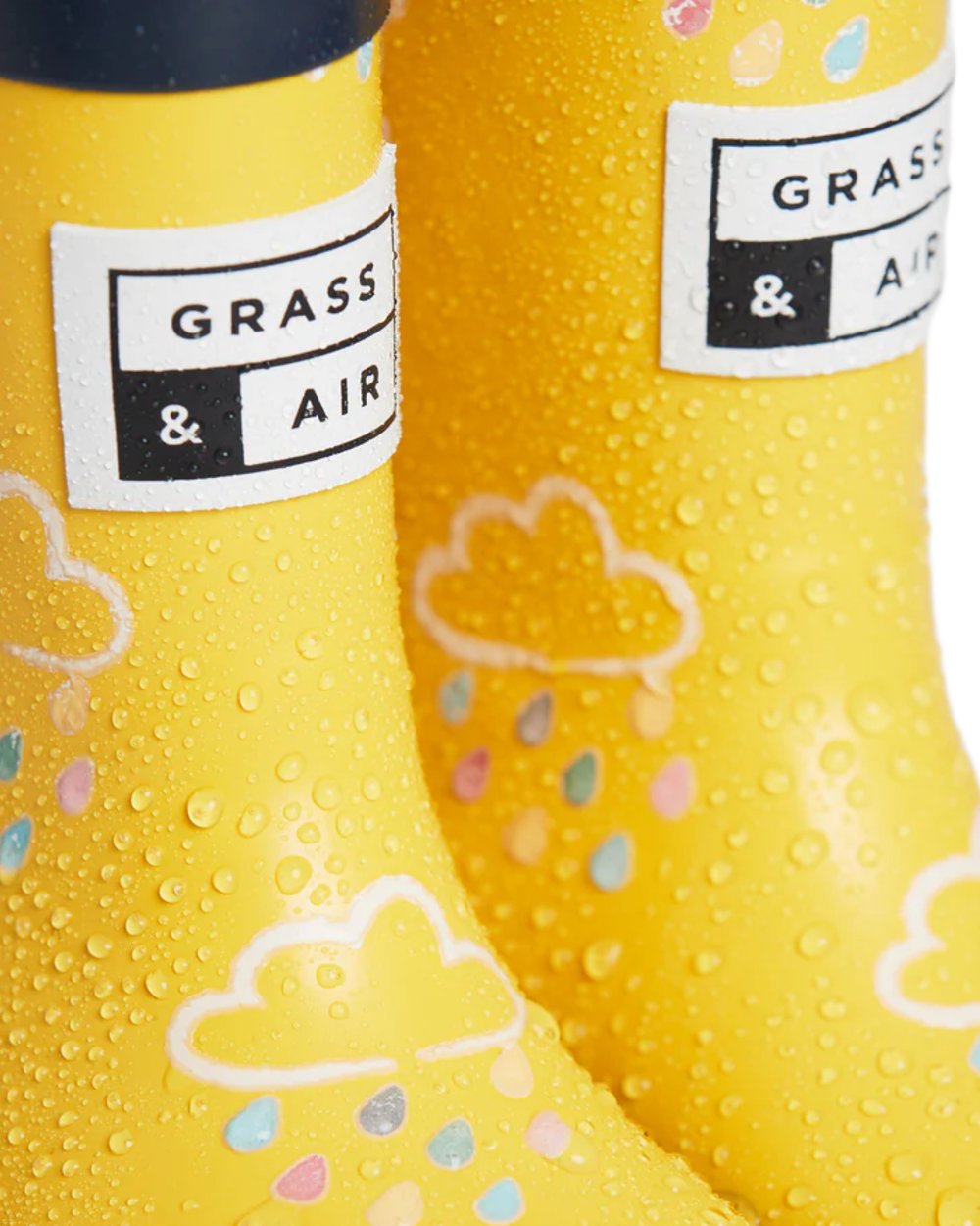 Yellow coloured Grass &amp; Air Childrens Colour-Revealing Wellies on white table background 