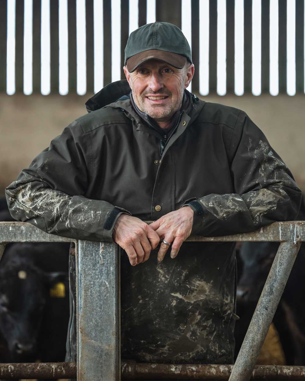 Green coloured Hoggs of Fife Green King II Waterproof Smock on barn background with livestock 