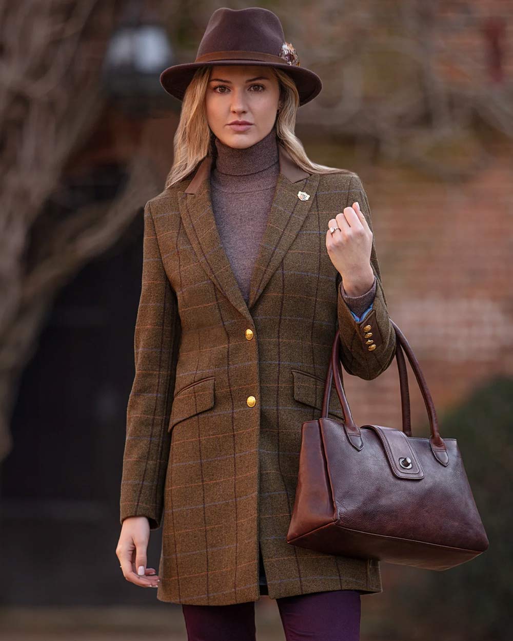 Woman in richmond felt hat with leather handbag wearing Alan Paine Combrook Ladies Mid Thigh Coat in Hazel 