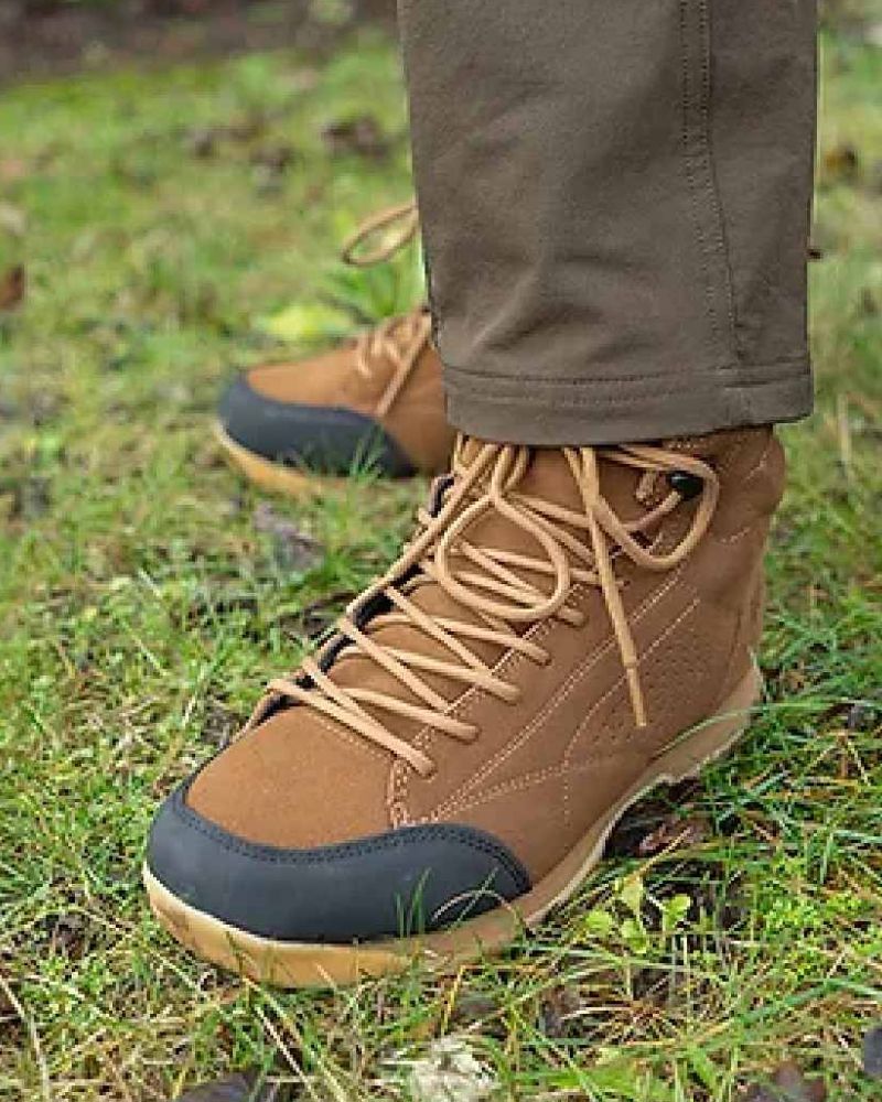 Tan Jack Pyke Lowland boots worn with green trousers on a grass surface. 