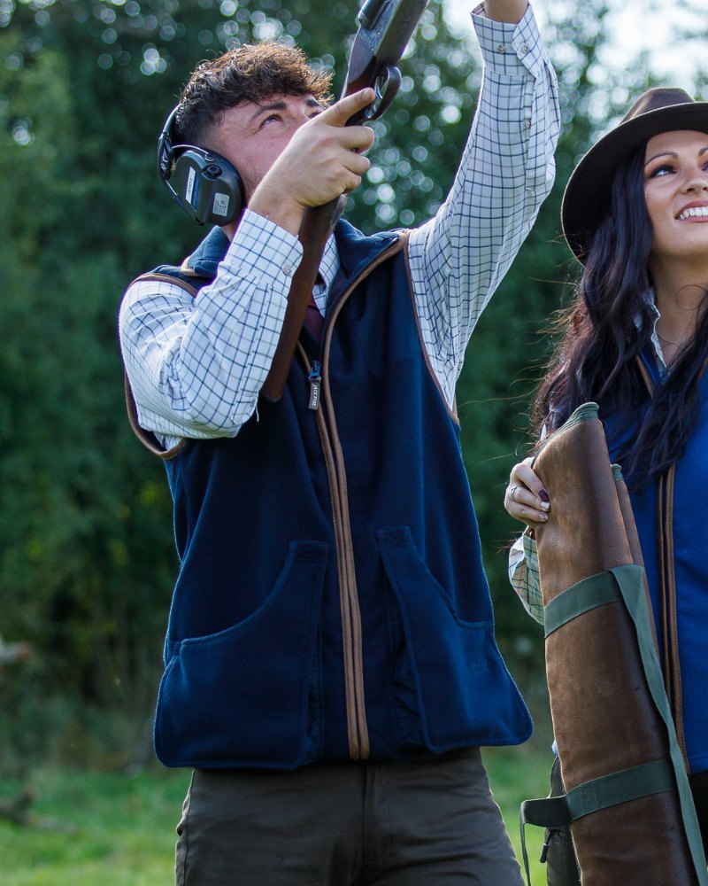 Two people wearing Jack Pyke shooting gilets during an outdoor clay shooting session