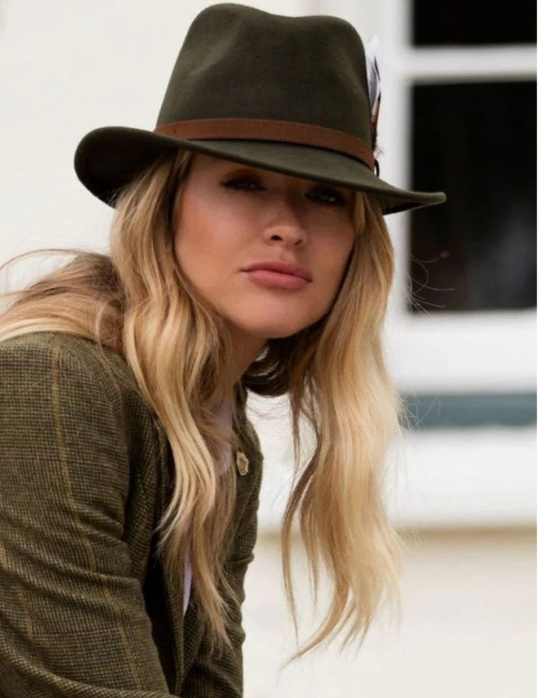 Woman wearing an Alan Paine olive green country hat with feather detail outdoors